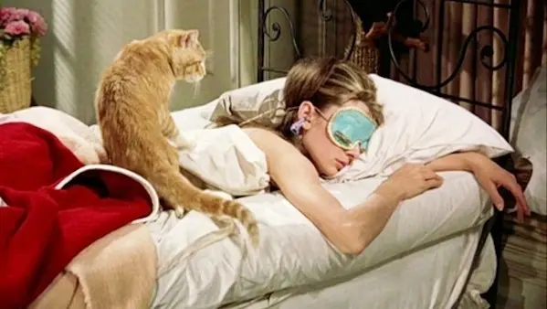 Audrey as holly in sleep mask with cat on back